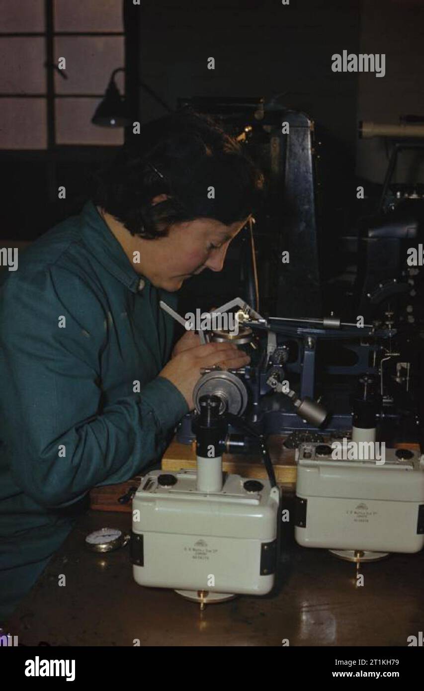 Donne Lavoratori di guerra in Gran Bretagna, 1945 In una fabbrica a Camberwell, Londra abili artigiani rendono gli strumenti di precisione. Una donna lavoratrice di guerra imposta una macchina per il taglio del reticolo di precisione dello strumento di misura. Foto Stock