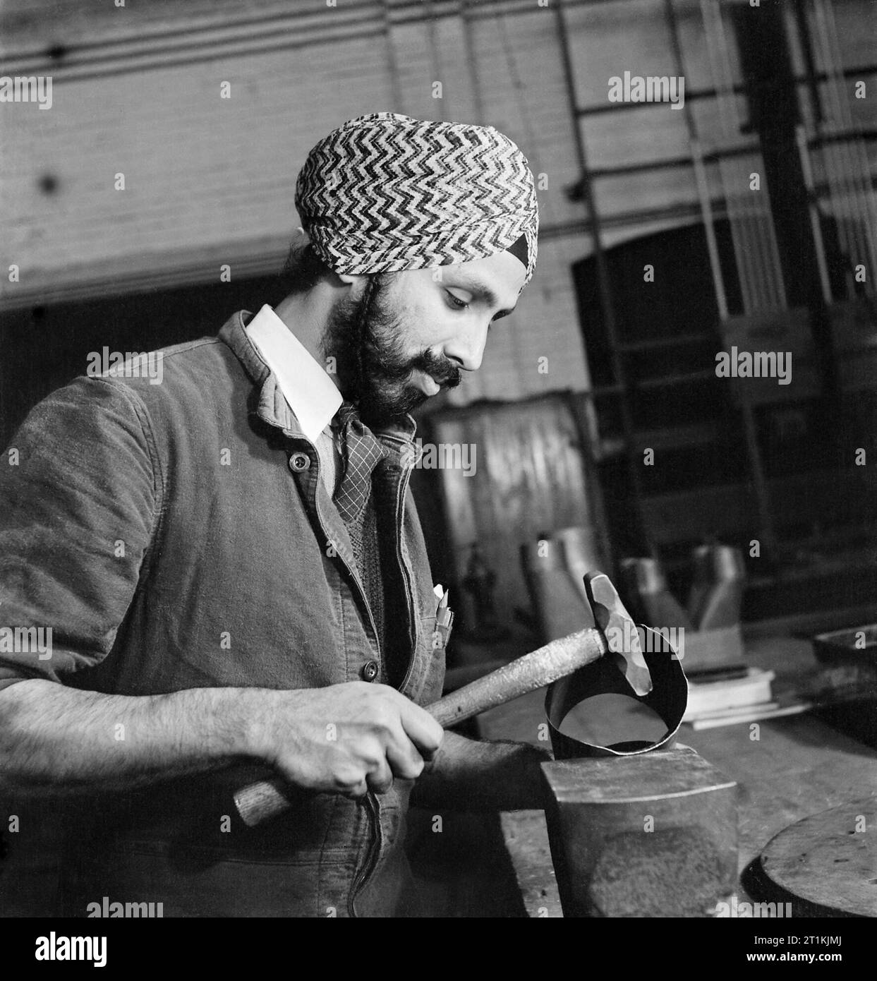 Un tecnico Sikh che lavora con tubi in metallo presso il Government Training Centre di Letchworth nel 1941. Foto Stock