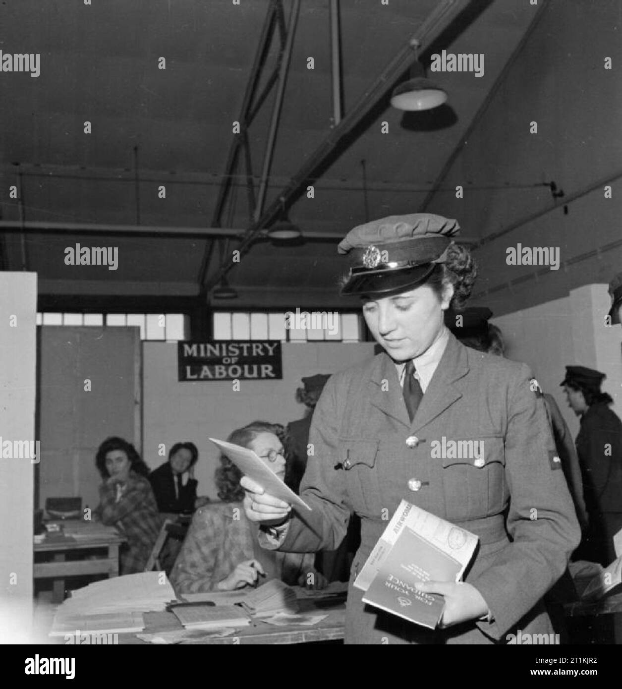 La smobilitazione dei membri della donna Royal Air Force Aircraftwoman leader Vera Blackbee delle donne ausiliario della Air Force (WAAF) raccoglie più documenti ufficiali di aver firmato con un rappresentante del ministero del Lavoro al WAAF Centro di smobilitazione, RAF Wythall. Foto Stock