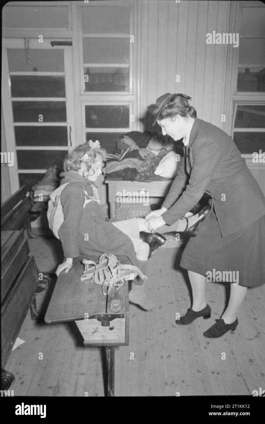 Dutch i bambini rifugiati- arrivo in Gran Bretagna a Tilbury, Essex, Inghilterra, Regno Unito, 1945 presso un centro di riposo di Tilbury, un neo arrivata olandese rifugiato ha il suo ginocchio vestito dal suo maestro. Secondo la didascalia originale, ha ferito suo ginocchio mentre a bordo della nave. Foto Stock