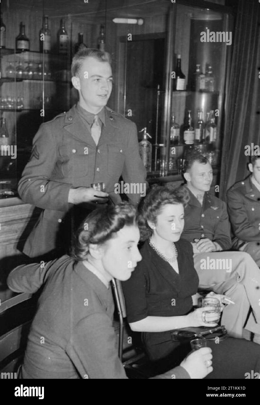 Empire - e il mondo - Partito- Radio Broadcast dal Club d'oltremare, St James's London, 1942 Un gruppo di due americani e due britannici ascoltare la trasmissione dalla hall dell India al Club d'oltremare. Da sinistra a destra essi sono: ACW2 Patricia Graham WAAF (da di Ripley, Hampshire), caporale H Bielski (in piedi, da Rapid City, il Dakota del Sud), ACW2 Maclean WAAF (era a Tangeri fino a 4 anni fa), e tenente Peyton Mathias (da Montgomery, Alabama). Foto Stock