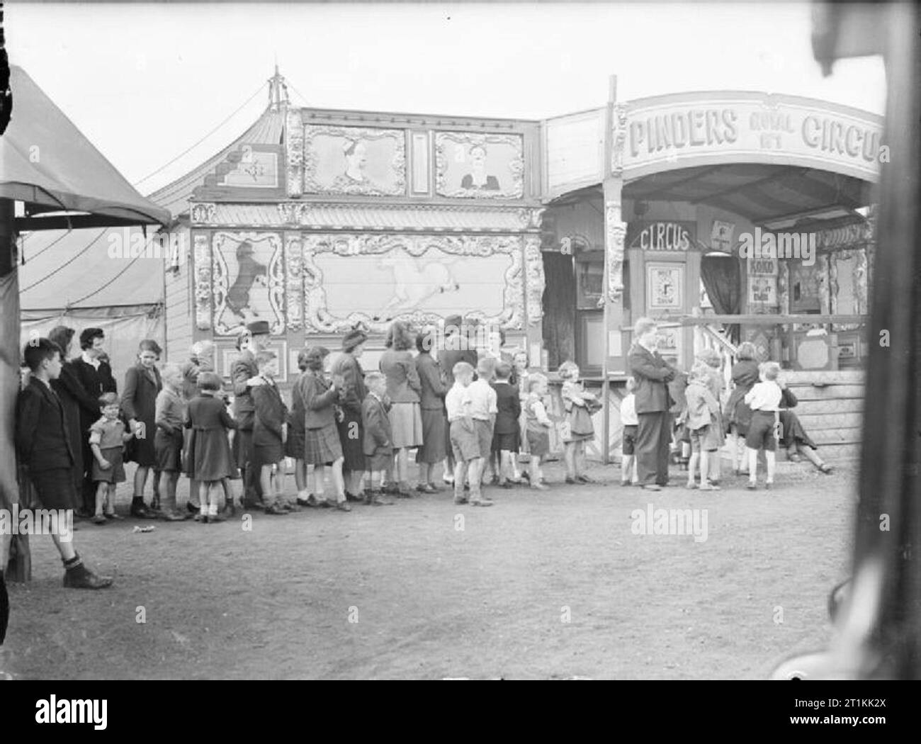 Intrattenimento in tempo di guerra a Glasgow, in Scozia, 1943 uomini, donne e bambini in coda fuori Pinders Circus su Glasgow Green, 1943. Foto Stock