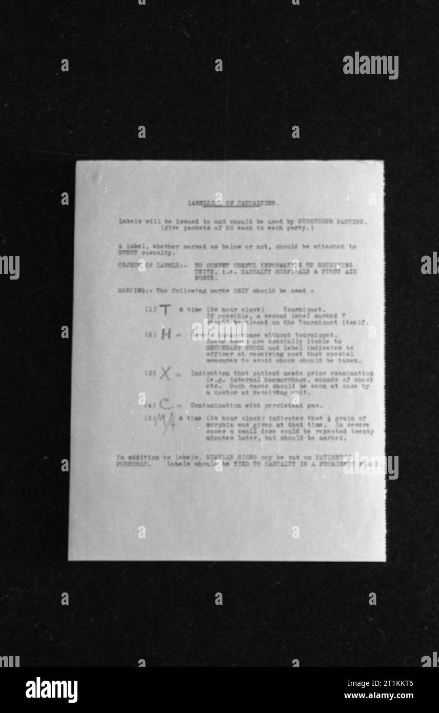 Guy's Hospital- la vita in un ospedale di Londra, Inghilterra, 1941 Questa fotografia mostra un grafico rilasciato a barella parti per quanto riguarda l'uso di particolari le etichette per le vittime. Ci sono cinque etichette chiave elencati: T (+tempo) indica il tempo che un laccio emostatico è stato posto sulla vittima (per esempio T 14:30 indica che un laccio emostatico è stato posto a 2:30pm); h indica che il paziente ha subito una emorragia e che un laccio emostatico non è stata applicata; C indica che il paziente è stato contaminato con gas; M 1/4 (+ tempo) indica che il paziente è stato dato 1/4 grano di morfina e ti Foto Stock