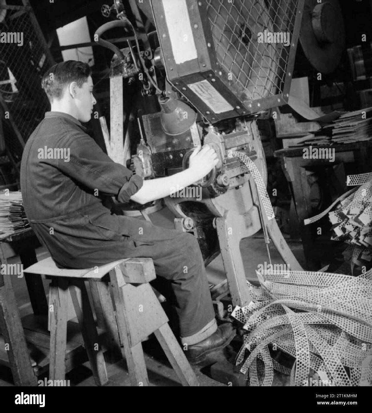 Lettera in Bullet- girando recuperati carta in cartucce di fucile, Inghilterra, 1942 Questa fotografia mostra i resti del fustellato delle strisce di cartone come essi vengono scartati dalla macchina punzonatrice. Appena visibile sulla sinistra della fotografia sono le strisce di cartone prima di essere alimentati alla macchina. Foto Stock