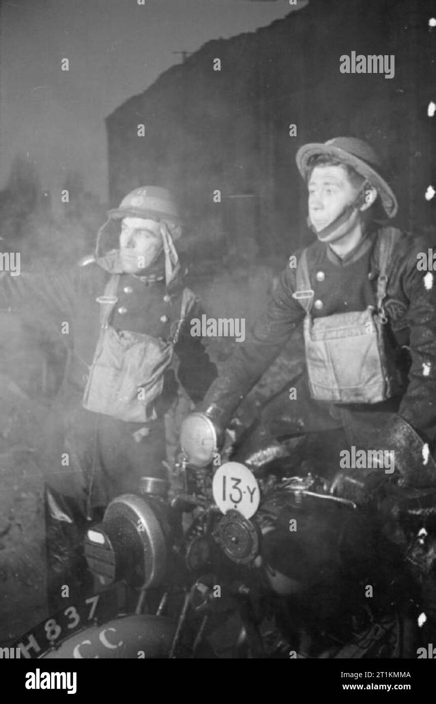 Londra Afs- Uomini di ausiliari di servizio antincendio a Londra, C 1940 il delegato in carica alla scena di un incendio racconta di un dispatch rider che ci sono persone intrappolate nel seminterrato dell'edificio interessato. Il dispatch rider sarà quindi trasmettere le relative informazioni per la sede centrale e per i servizi medici. Foto Stock