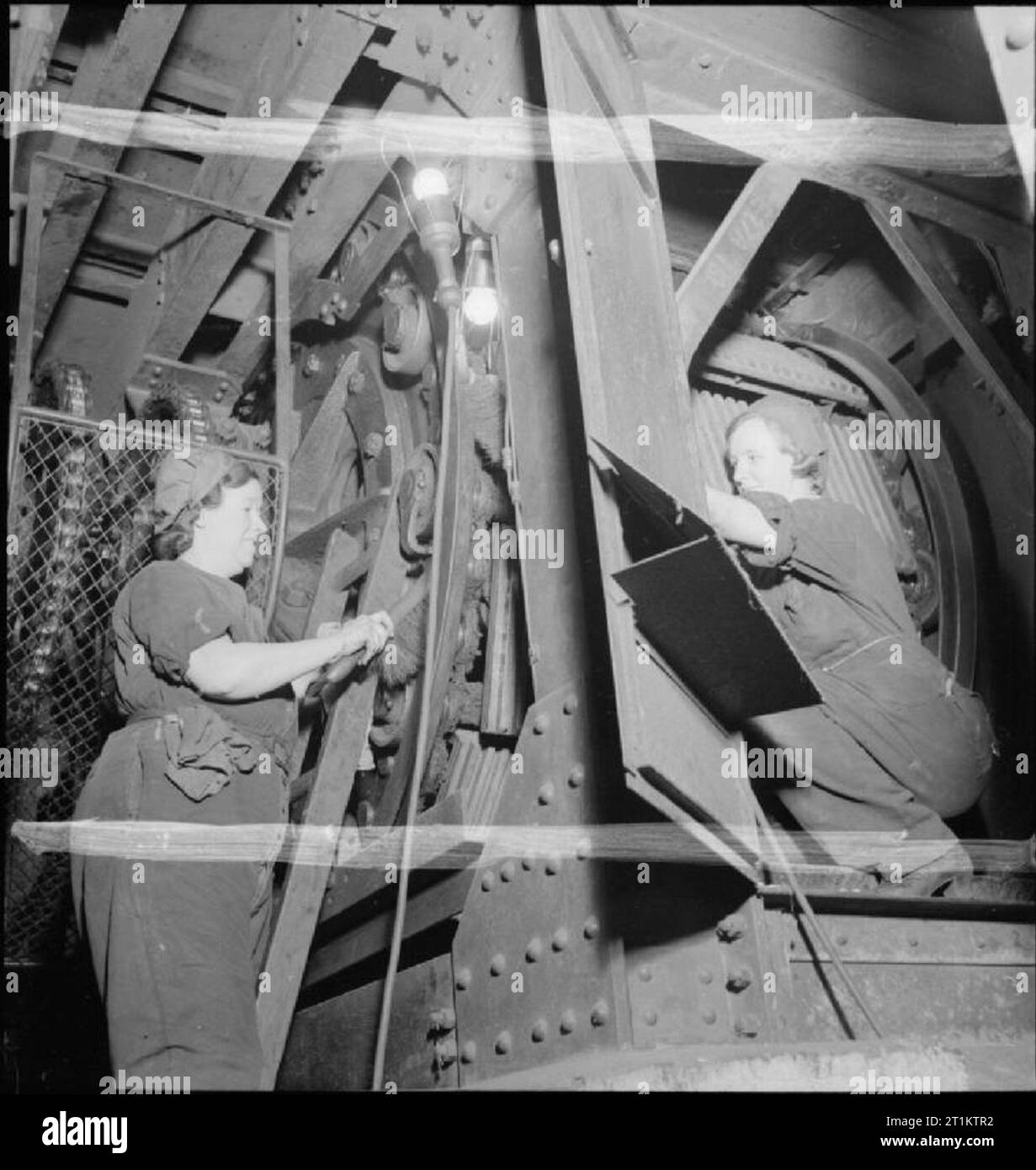 Ferrovia Metropolitana le donne- Donne al lavoro su Londra tubo della rete, 1942 Mrs Philpotts L (sinistra) e la Sig.ra E Firth effettuare alcune indispensabili interventi di manutenzione per le scale mobili in corrispondenza di una stazione della metropolitana di Londra. Secondo la didascalia originale 'London's 'metro' ha uno dei più elaborati sistemi di scale mobili nel mondo". Onorevole Philpotts e la signora Firth sta lavorando sotto le scale mobili, in modo che le fasi di per sé non sono visibili. Foto Stock