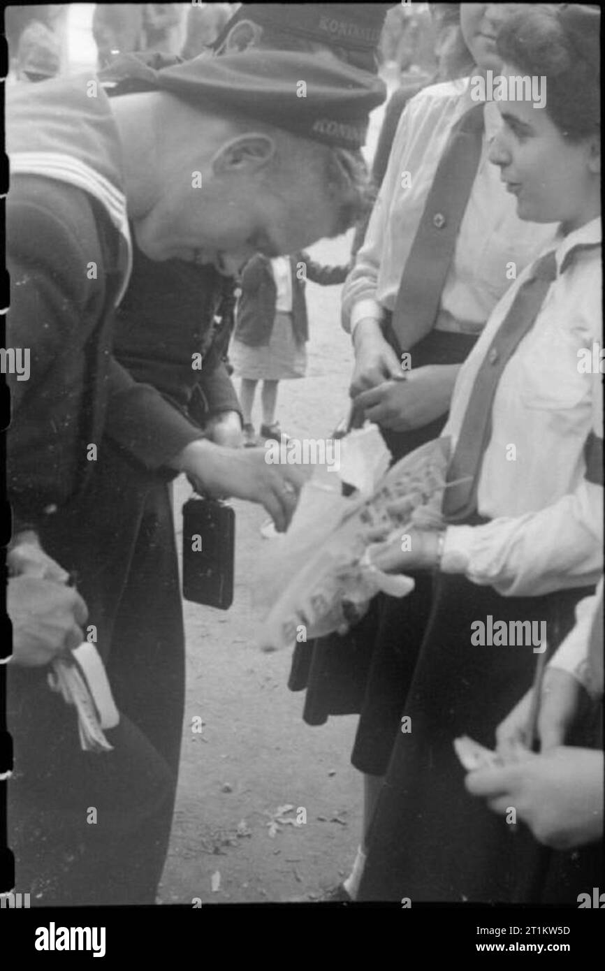 Fiera di guerra - Vacanze a casa a un fete in Russell Square, London, 1943 Un marinaio olandese si arresta per acquistare un biglietto di lotteria da un membro della Croce Rossa di cadetti a Russell Square fete. Il premio è un modello corazzata. Foto Stock