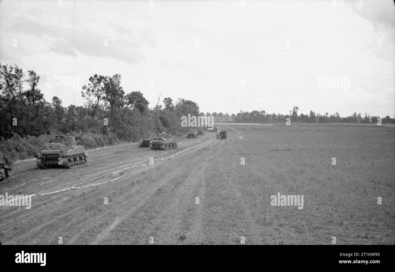 L'esercito britannico in Normandia 1944 Sherman serbatoi della XI divisione corazzata passate a fianco di un legno, 26 giugno 1944. I nastri indicano la corsia di marcia è libera di mine. Foto Stock