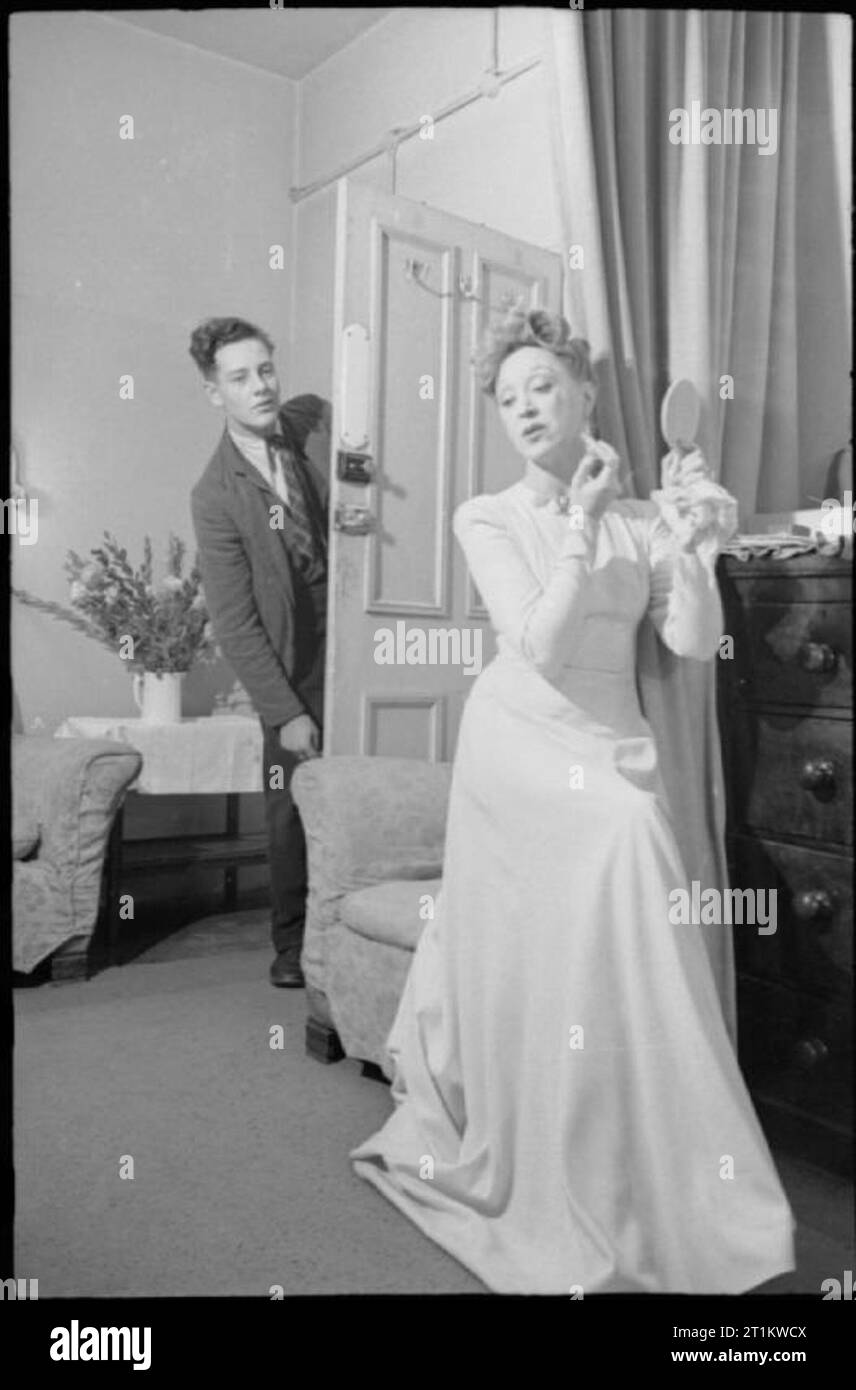 Teatro di guerra- Intrattenimento in London, England, Regno Unito, Agosto 1943 Tony Wotton chiamate Binnie Hale per lo stadio dalla porta del suo spogliatoio al Lyric Theatre, Shaftesbury Avenue, come lei si mette il tocco finale al suo make-up. Il suo collega attore in 'Flying Colours' è Douglas Byng e il suo rapido-routine di cambiamento "Revival' è solo all'inizio. Binnie aiuta sempre a lui con i suoi cambiamenti di ali. Foto Stock