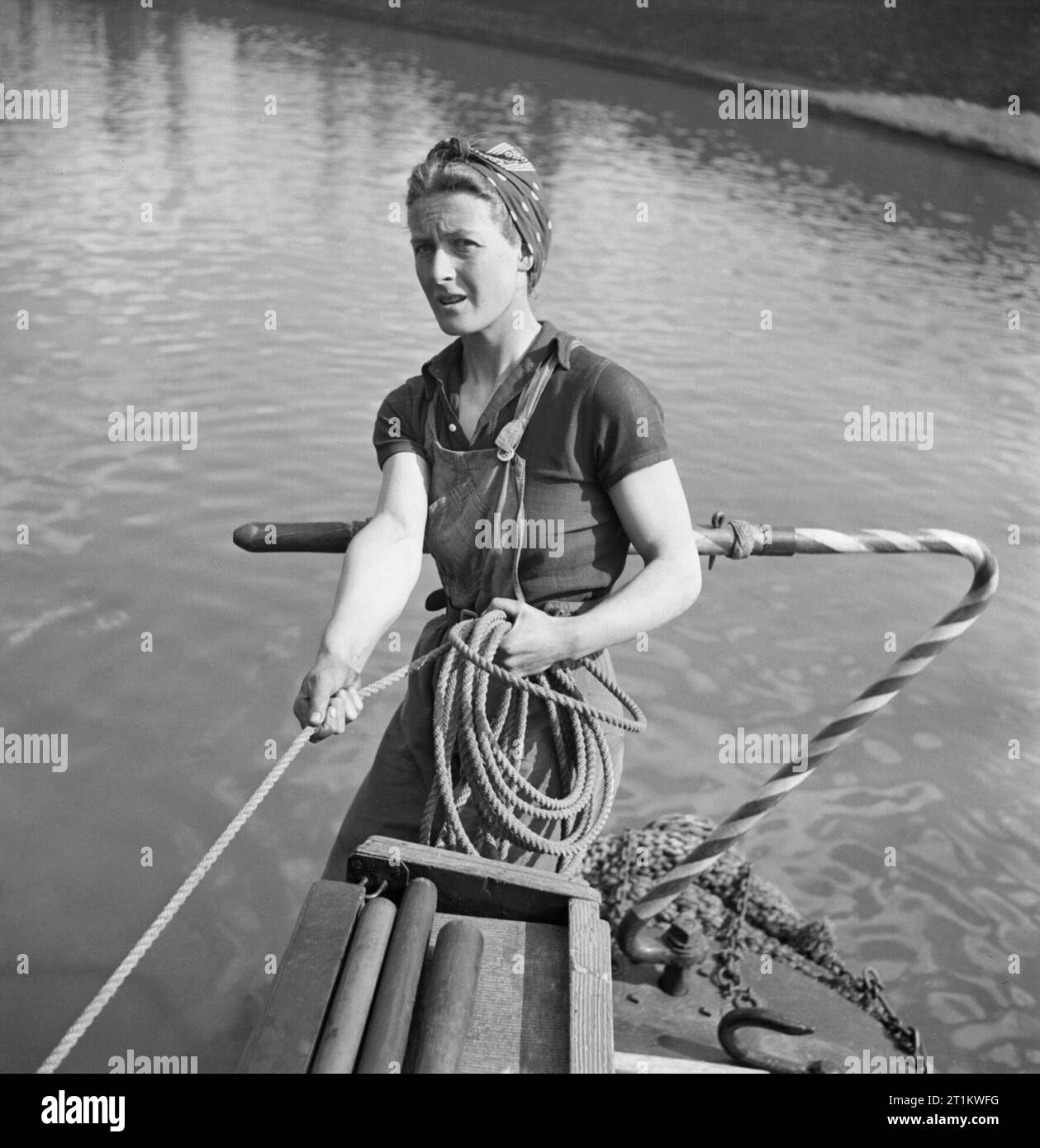 Le donne correre una barca- La vita a bordo della chiatta sul canale "heather Bell', 1942 Miss marzo tenere su una fune come lei sta al timone a bordo del 'HEATHER BELL'. Foto Stock