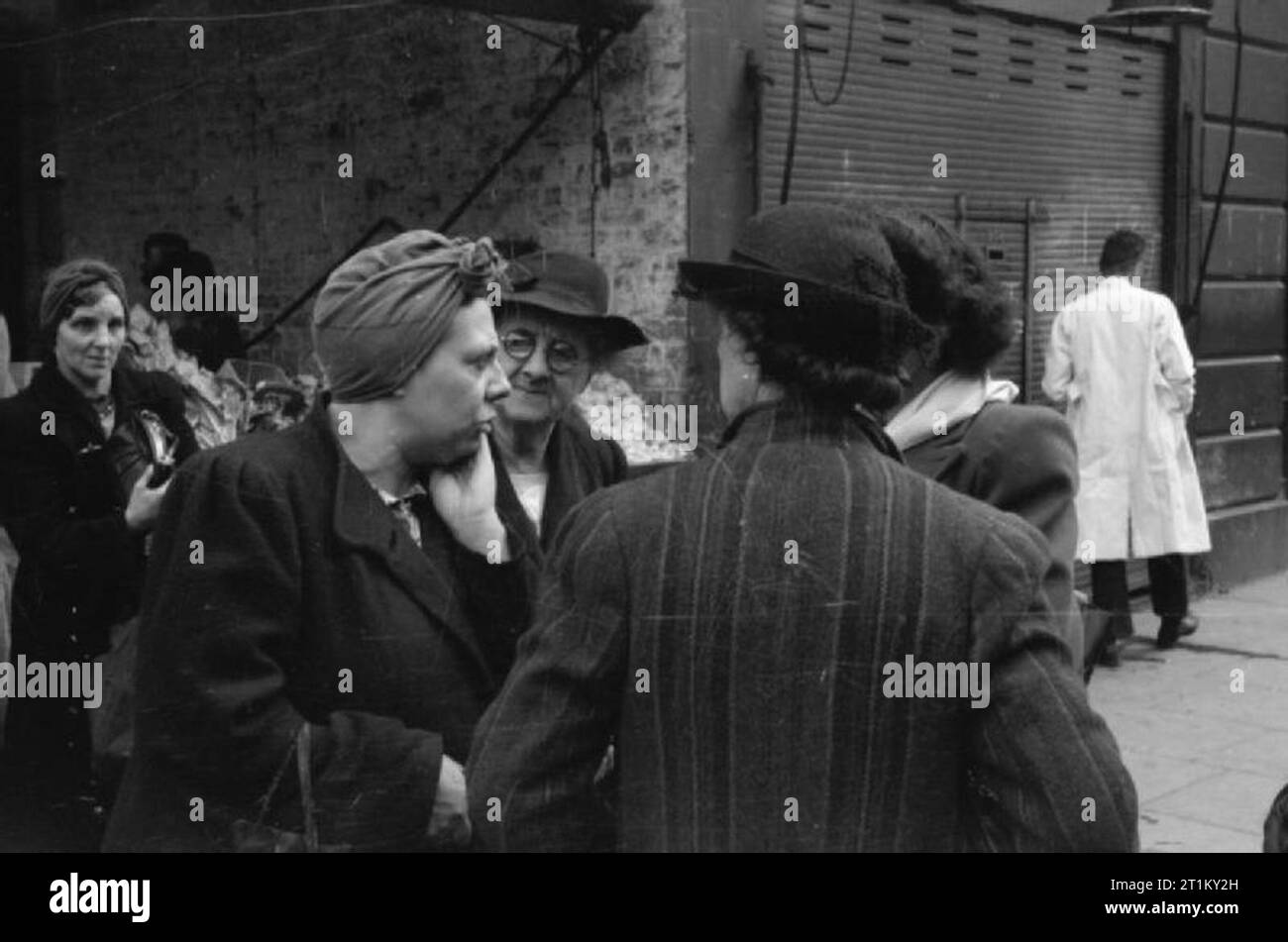 La Gran Bretagna Code per cibo- razionamento e la scarsità di cibo in tempo di guerra, Londra, Inghilterra, Regno Unito, 1945 Un gruppo di casalinghe di discutere il problema della scarsità di cibo durante un viaggio di shopping, da qualche parte a Londra. Foto Stock