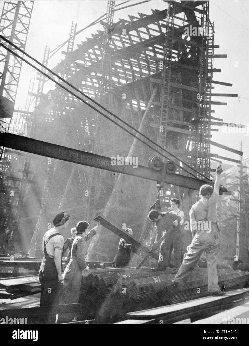 La Gran Bretagna è Home Front 1939 - 1945- Le donne che lavorano nei cantieri navali di donne che dà il segnale per il sollevamento di travi di acciaio presso un cantiere in Gran Bretagna. Foto Stock