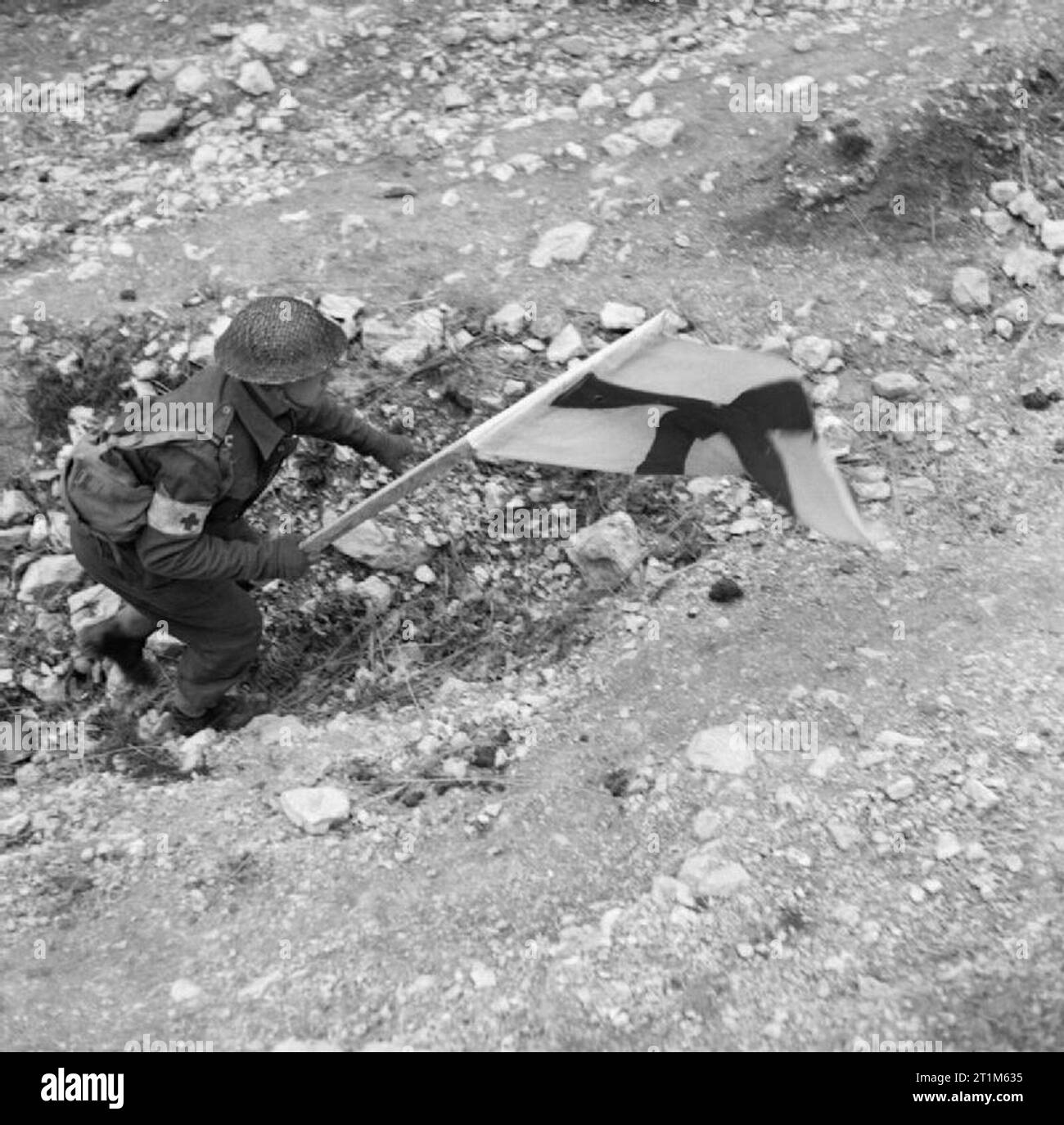 Un medico RAMC ordinato fa il suo modo di procedere sotto la copertura della bandiera della Croce Rossa per recuperare un incidente nel corso dei combattimenti a Cassino, 24 marzo 1944. La catena di medici di evacuazione: un ordinato RAMC fa il suo modo di procedere sotto la copertura della bandiera della Croce Rossa per recuperare un incidente nel corso dei combattimenti a Cassino. Foto Stock
