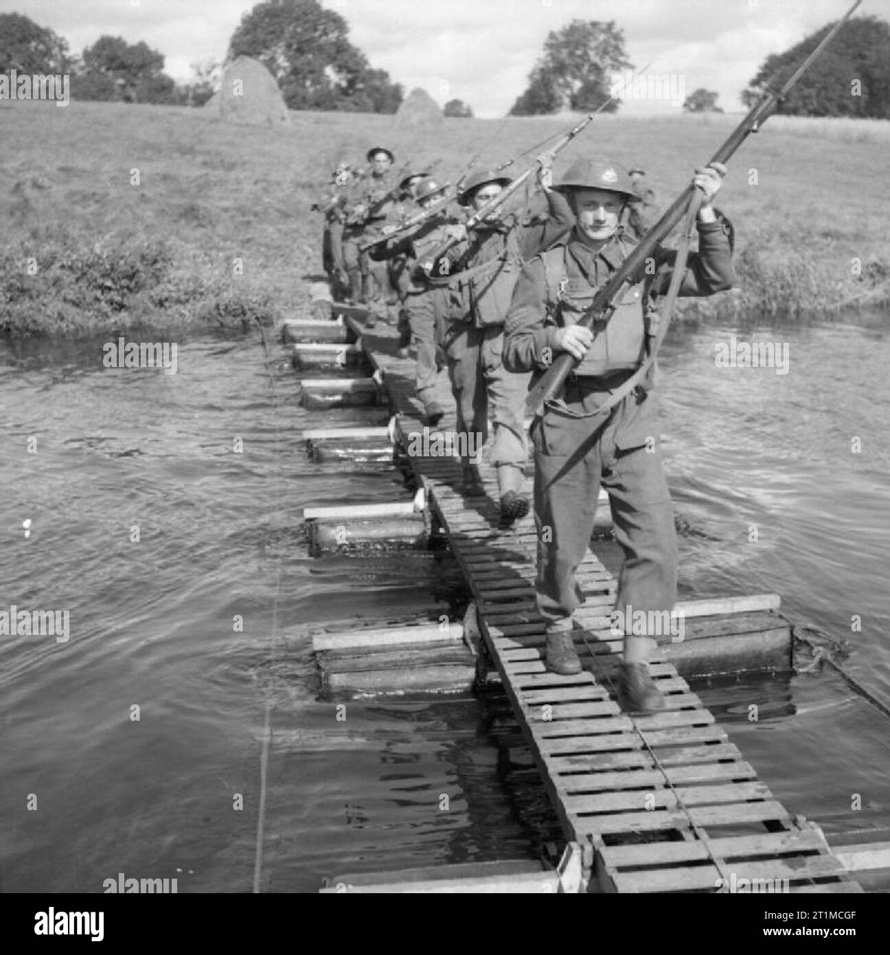 L'Esercito Britannico nel Regno Unito 1939-45 uomini del 8° Sherwood guardaboschi attraversare un fiume con un piccolo kapok pontoon bridge, Dunadry in Irlanda del Nord, 28 agosto 1941. Foto Stock