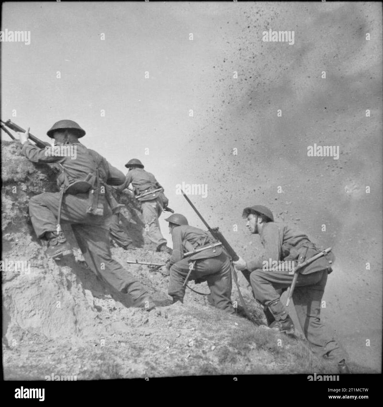 L'Esercito Britannico nel Regno Unito 1939-45 come una carica esplode nelle vicinanze, le truppe del primo battaglione, duca di Wellington il reggimento arrampicate cliffs durante un live-esercizio di sparo a Cromer in Norfolk, 21 aprile 1942. Foto Stock