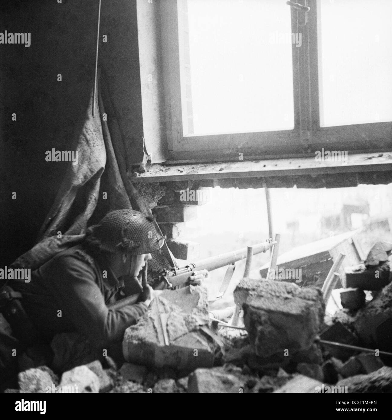 La campagna in Europa nord-occidentale 1944-45 Serjeant J. Welch del xv (scozzese) Divisione sparando dalle rovine di una casa a Goch, 21 febbraio 1945. Foto Stock