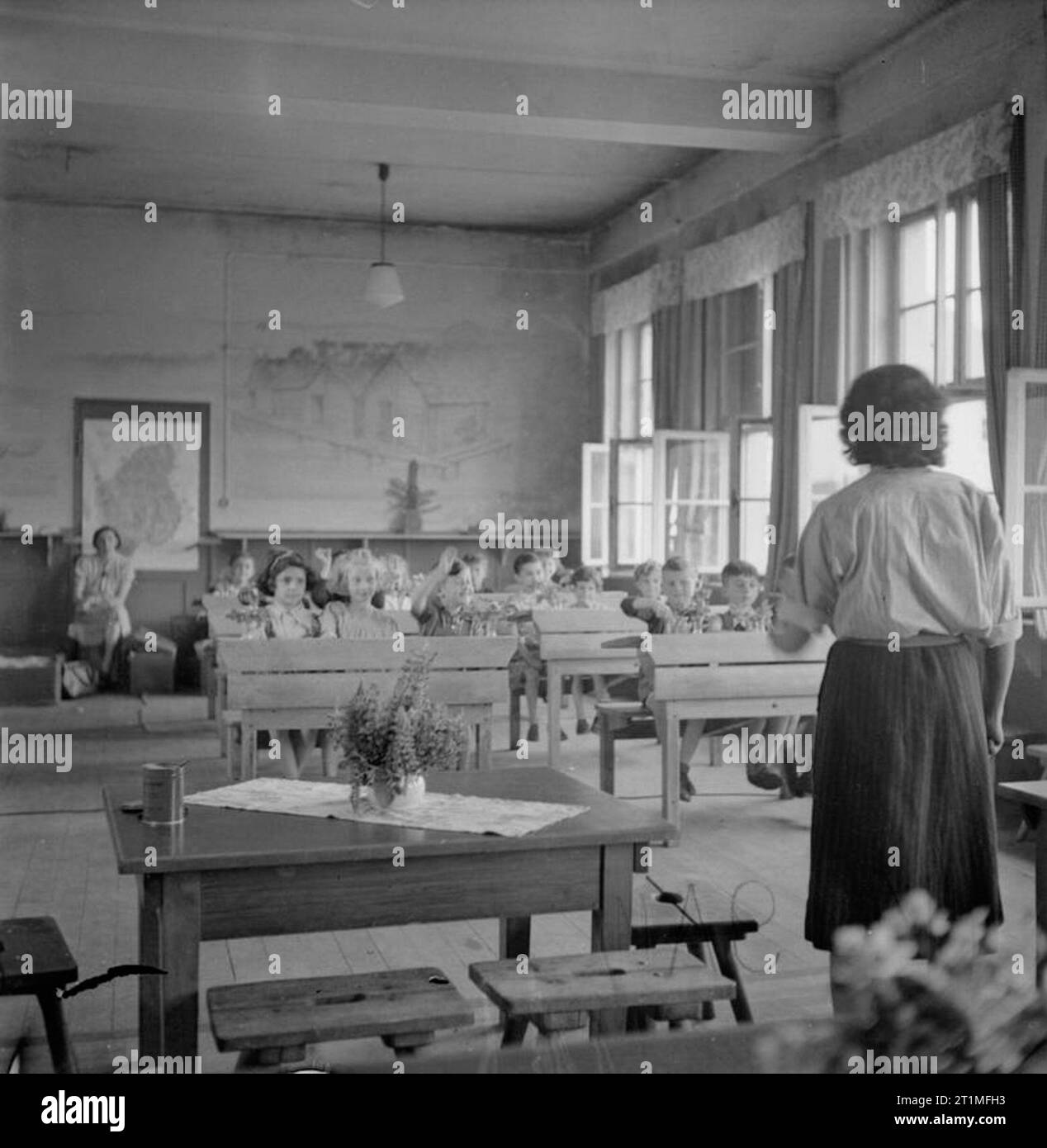 La liberazione di Bergen-belsen Campo di Concentramento, giugno 1945 ai bambini viene insegnato a scrivere nella scuola che ha aperto nel campo dopo la liberazione. I bambini venuti dalla Polonia, Cecoslovacchia e l'Ungheria, sono insegnate da Irene Mandel, una scuola ceca maestro che fu internata nel campo. Miss Mandel ha parlato di cinque lingue, ma insegnato in tedesco, l'unica lingua a tutti i bambini compresi. Foto Stock