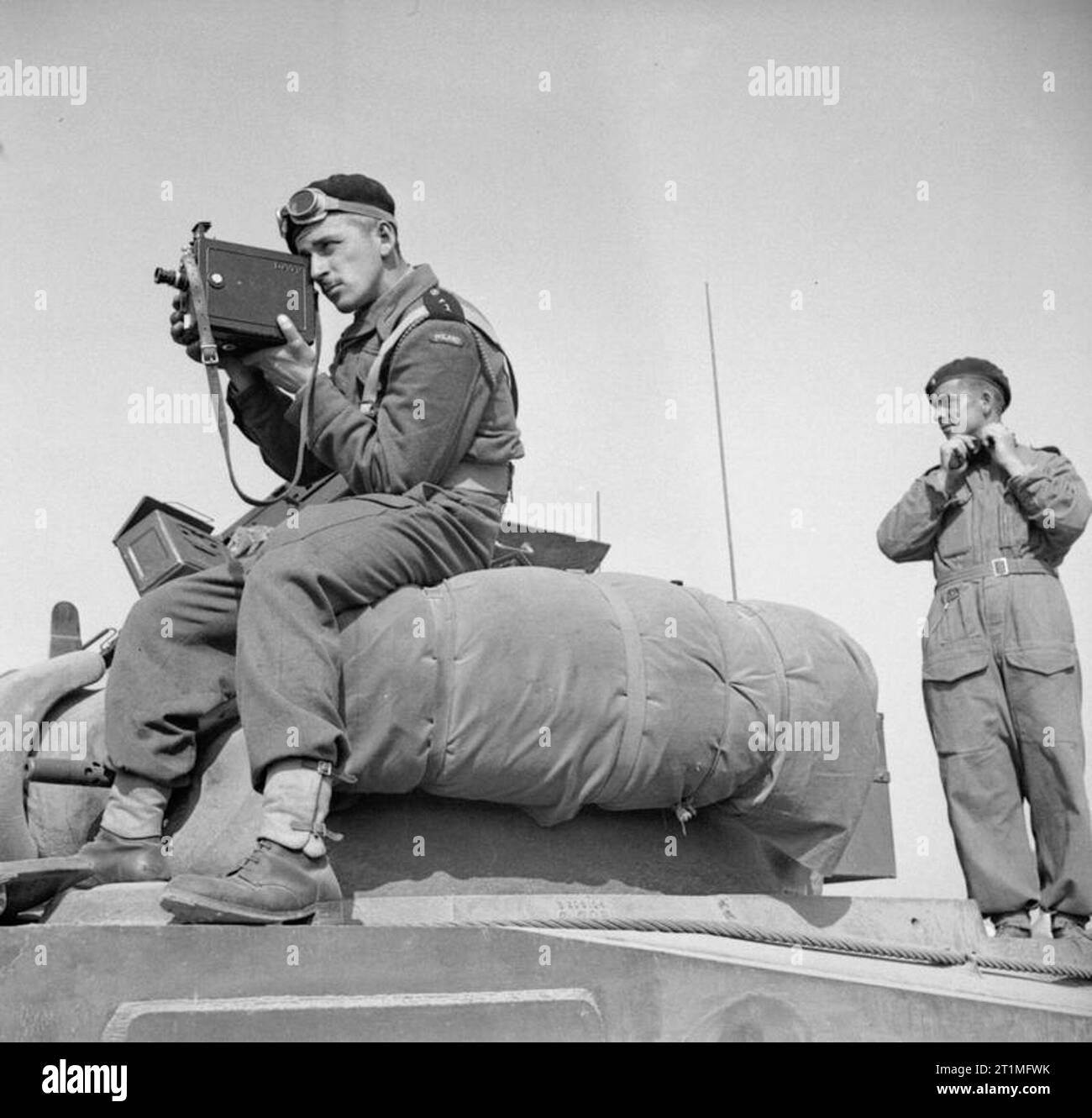 L'Esercito Polacco nella campagna di Normandia, 1944 cameraman in uniforme: 2 Tenente Jerzy Januszajtis, un esercito polacco Film cameraman unità di pellicole dalla parte superiore di un serbatoio di Sherman del primo polacco divisione corazzata serbatoio durante il funzionamento 'Totalise', a sud di Caen, Normandia il 8 agosto 1944. Egli è utilizzando un De Vry videocamera montata con una fionda. Foto Stock