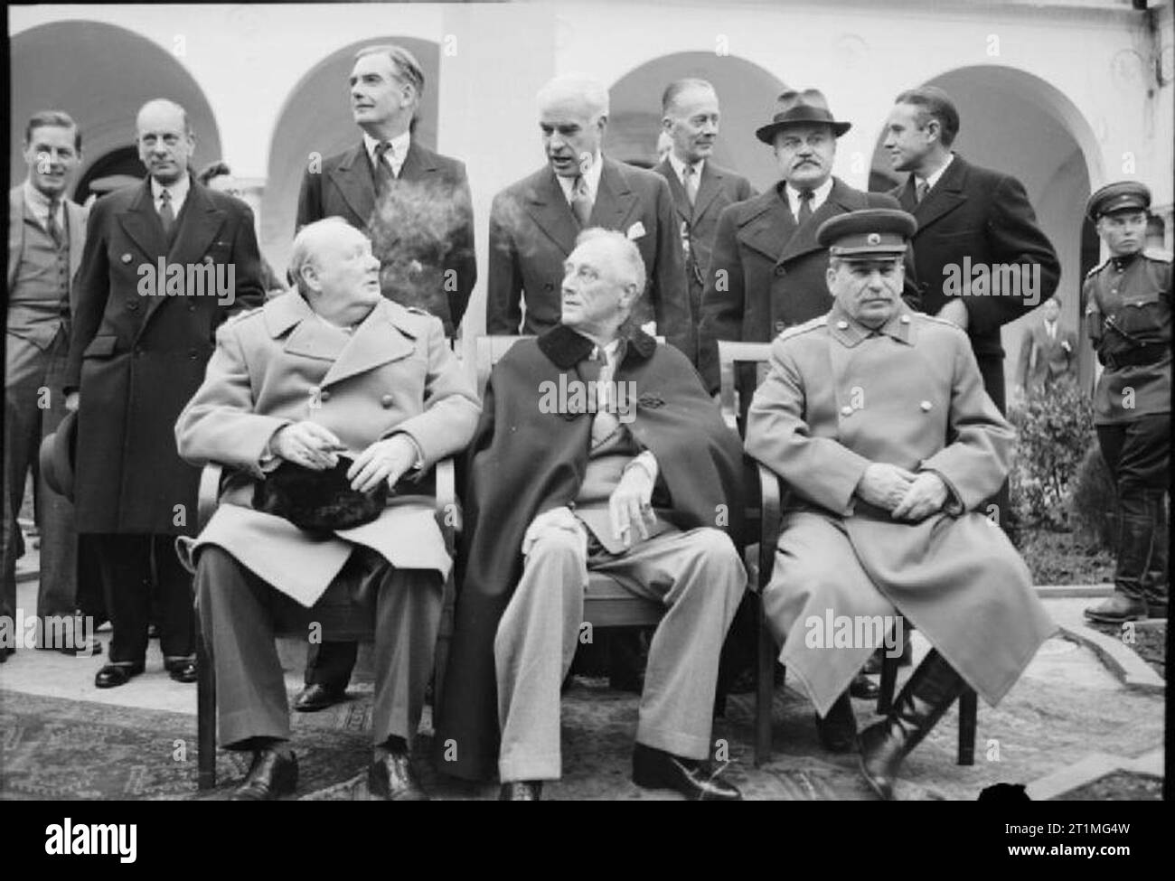 La Conferenza di Yalta, febbraio 1945 i " tre grandi ", Winston Churchill, il presidente Roosevelt e il Maresciallo Stalin, sedersi per una fotografia di gruppo al di fuori del palazzo di Livadia durante la conferenza di Yalta. Dietro di loro, da sinistra a destra, sono: un uomo non identificato; Signore pelli, il ministro britannico dei Trasporti di guerra; Rt Hon Anthony Eden MP, il Segretario degli esteri britannico; signor Edward Stettinius, il Segretario di Stato americano; Rt Hon Sir Alexander Cadogan, permanente britannico il Sottosegretario di Stato per gli Affari Esteri; signor Vyacheslav Molotov, sovietica di Commissario per gli Affari Esteri e il sig. Averell Harriman, Foto Stock