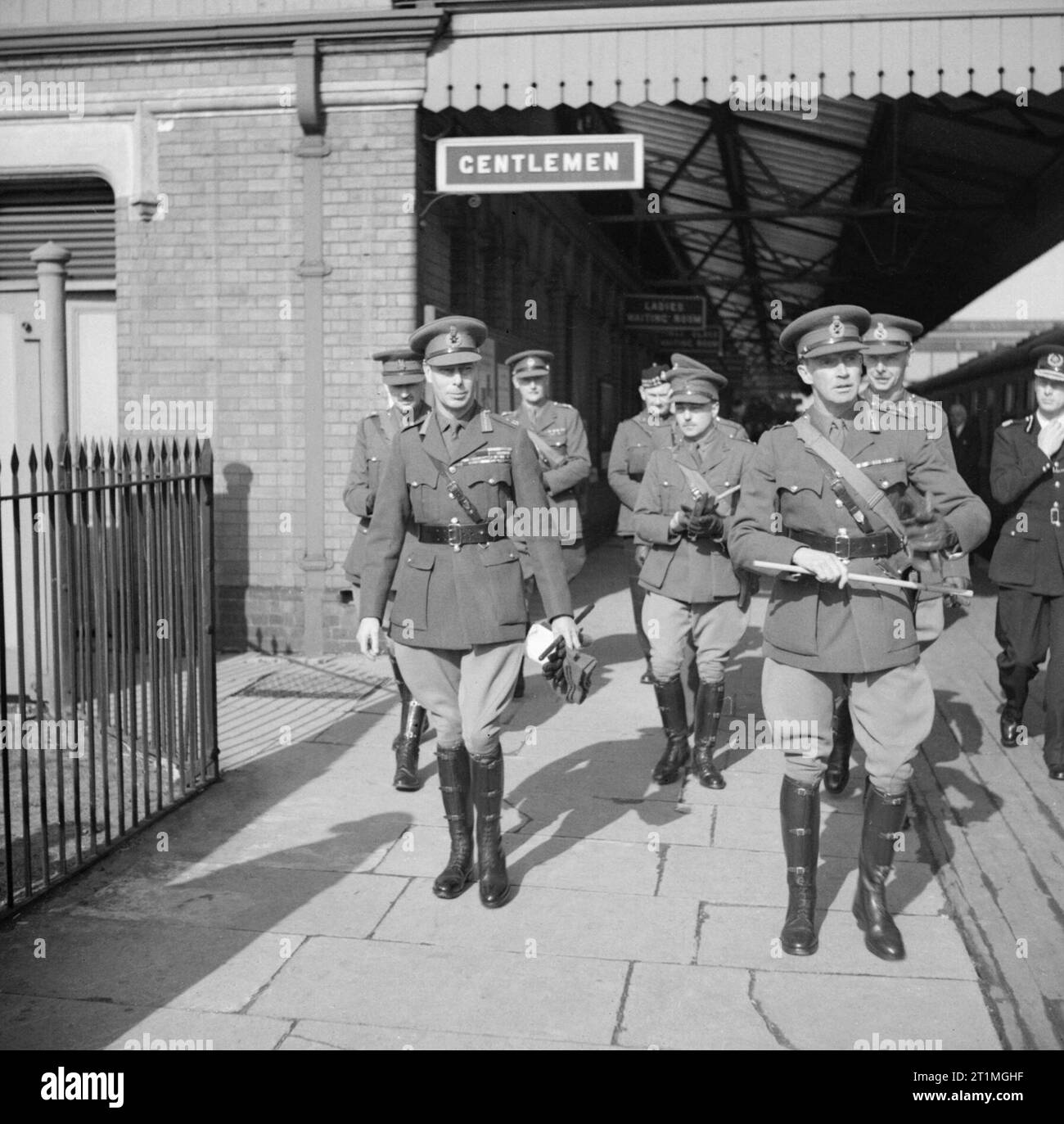 Re Giorgio VI (a sinistra) con ufficiali dell'esercito in una stazione ferroviaria quando è arrivato per ispezionare le truppe di 2nd divisione di fanteria a Burford-on-the-Water e Moreton-in-the-Marsh, Gloucestershire, 1 aprile 1942. Re Giorgio VI (a sinistra) con ufficiali dell'esercito in una stazione ferroviaria quando è arrivato per ispezionare le truppe di 2nd divisione di fanteria a Burford-on-the-Water e Moreton-in-the-Marsh, Gloucestershire, 1 aprile 1942. Foto Stock