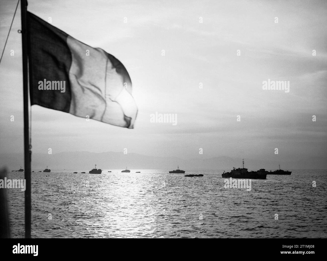 Alcuni di sbarco navi coinvolte nell'invasione Alleata dell'isola d'Elba, al largo della costa italiana, 16 giugno 1944. La figura mostra il tricolore francese volando a bordo LCH 240, parte della forza di invasione al tramonto alla vigilia degli sbarchi. Alcune delle navi della flotta di invasione si vede profilarsi da sun. Foto Stock