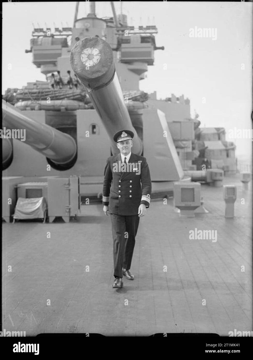 La Royal Navy durante la Seconda Guerra Mondiale a piena lunghezza ritratto di Ammiraglio Douglas Fisher a piedi la quarterdeck di HMS Duke of York. Parte del quadruple 14 pollici torretta Y può essere visto dietro di lui. Foto Stock