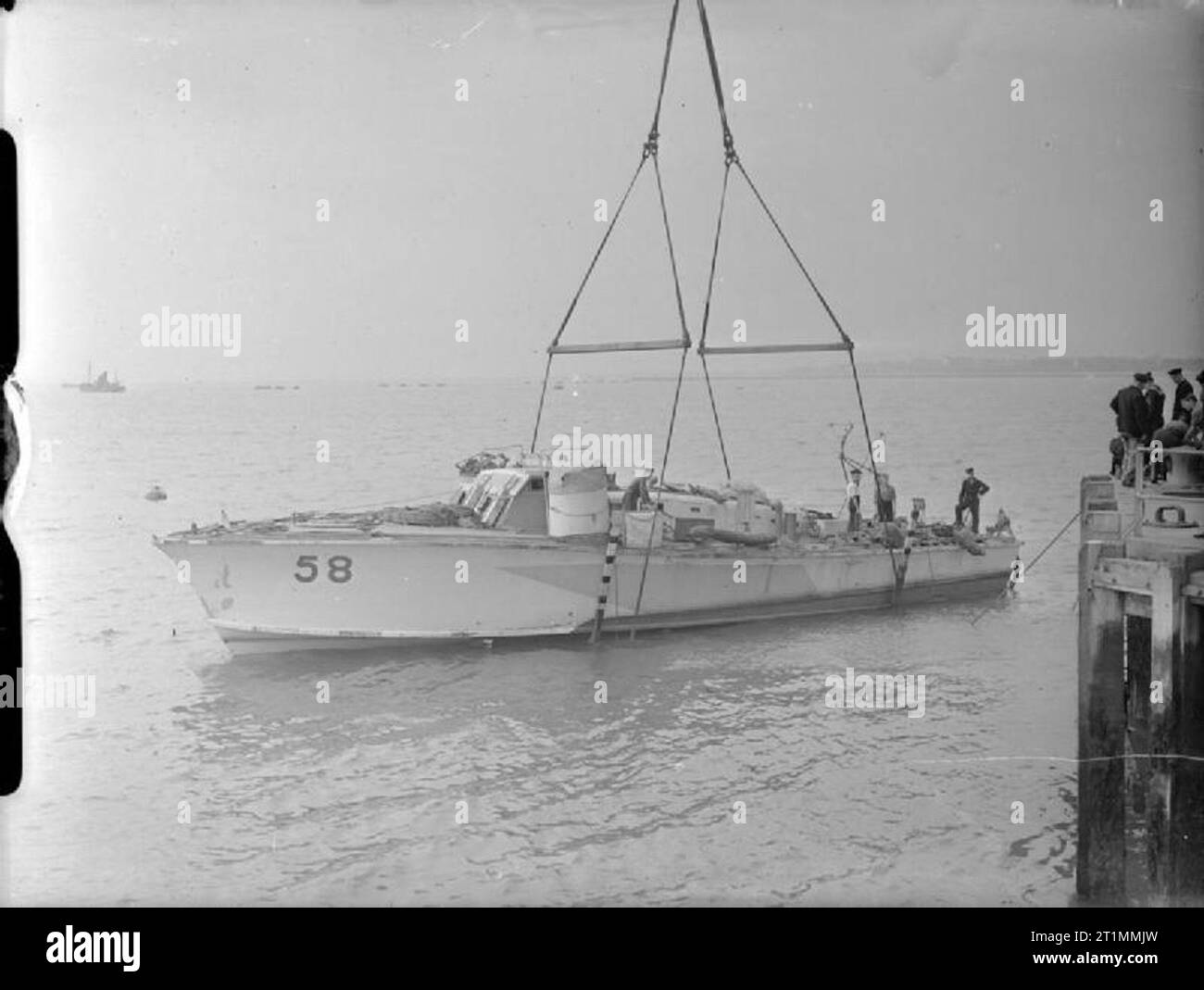 La Royal Navy durante la Seconda Guerra Mondiale una gru speciale scende un neo-riparato MGB 58 torna in acqua a Felixstowe. Una shore in base personale di sala motore artefici e maestri d'ascia a Felixstowe mantenuta la speedy artigianale della Gran Bretagna è luce forze costiere al top della condizione. Foto Stock