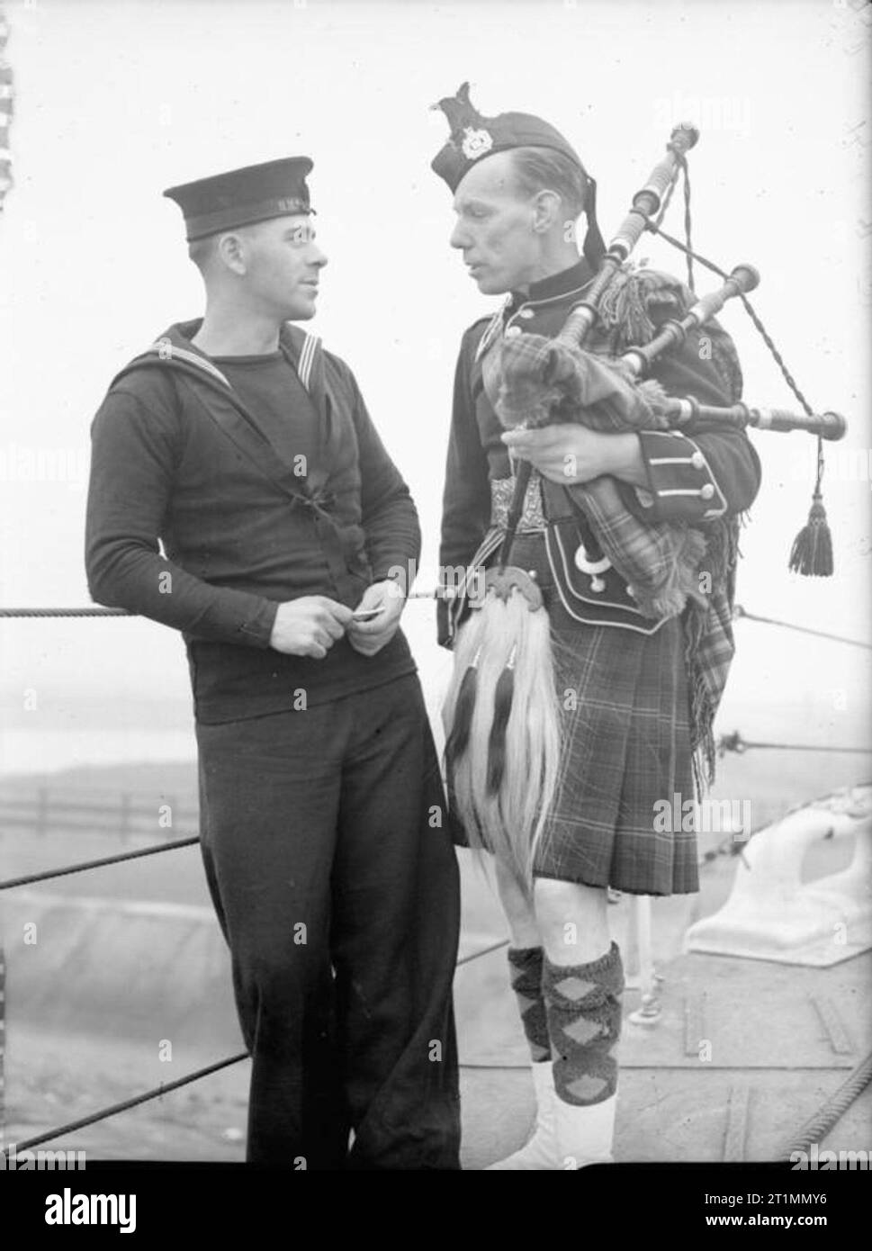 La Royal Navy durante la Seconda Guerra Mondiale in grado Seaman J P Taylor di Newcastle, con marinaio ordinario Alex MacPhee, di Campbeltown, Argyllshire, a bordo della HMS WAVENEY a Liverpool. MacPhee è in tradizionale abito scozzese Foto Stock