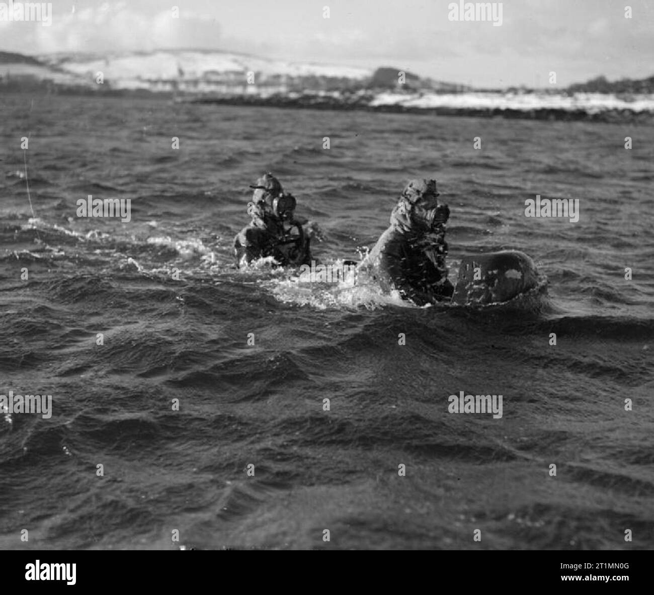 La Royal Navy durante la Seconda Guerra Mondiale due subacquei vestiti in tute di immersione uomo carro il loro mestiere come si procede in corso in Loch sforzati, vicino Rothesay, Scozia. Il carro è inizio a scendere al di sotto della superficie. Foto Stock