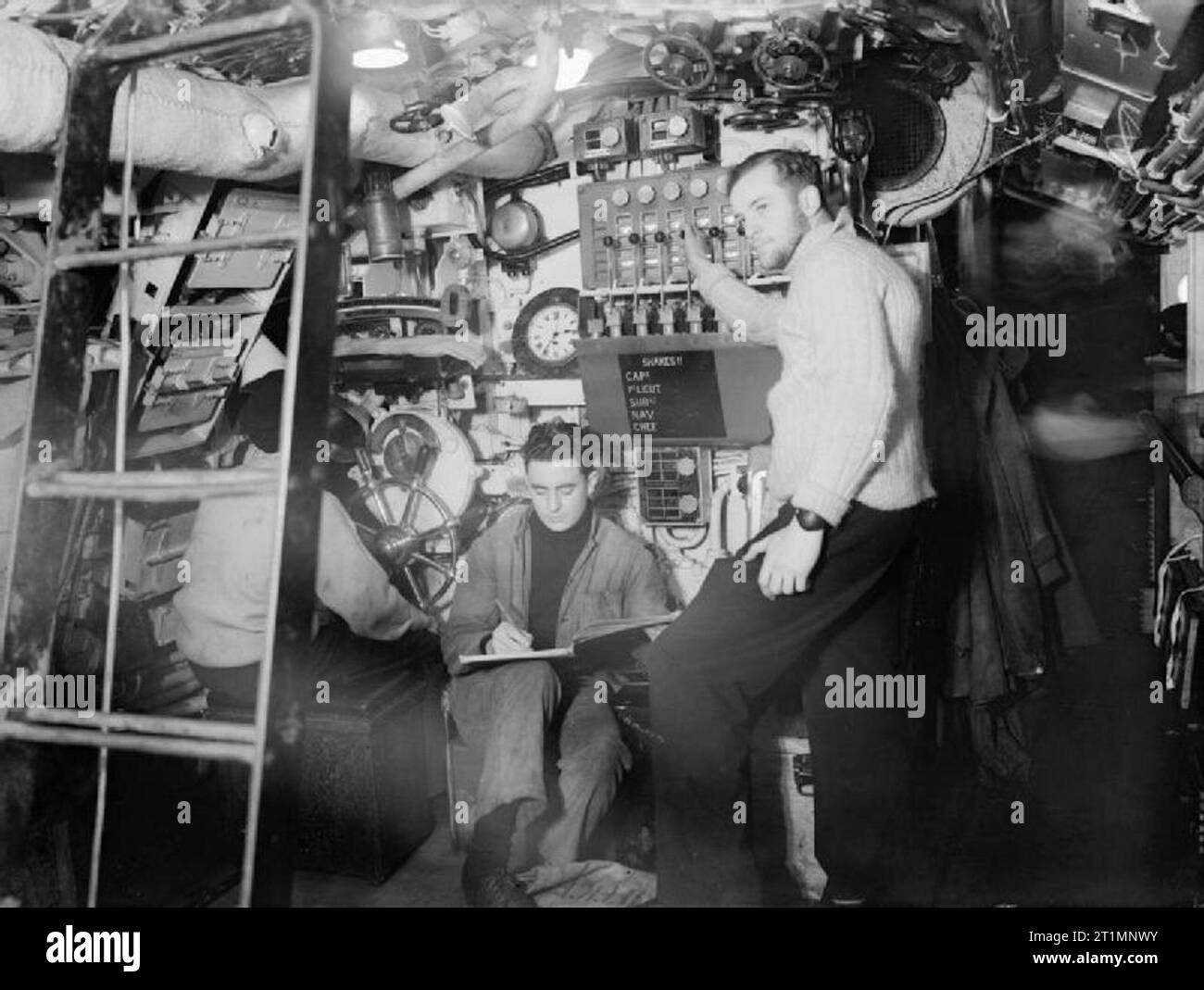 La Royal Navy durante la Seconda Guerra Mondiale "Torps' sotto il Tenente G F McKenzie, RNVR, presso il siluro sul pannello di controllo del HMSM SERAFINO, nel porto di Holyhead. Egli viene da Echuca, Victoria ed era a scuola prima della guerra. Mantenendo il registro di sparo con lui è in grado Seaman K R Payne, di Cleethorpes, Lincolnshire, che era nella marina mercantile prima della guerra. Foto Stock