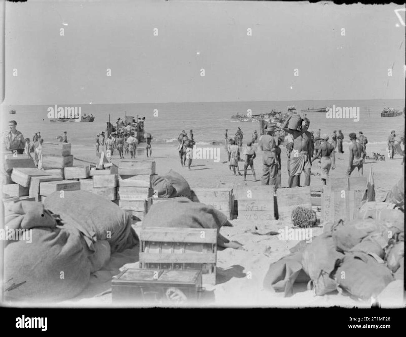 La Royal Navy durante la Seconda Guerra Mondiale isolani birmano aiutando a scaricare i negozi dopo la spiaggia era stata fissata a Cheduba , a sud di Ramree, Birmania. Royal Marines delle Indie Orientali flotta realizzati con successo un atterraggio sul isola Cheduba sotto la protezione di un bombardamento da incrociatori e cacciatorpediniere e copertura aerea fornita dalla Fleet Air Arm. Assault craft può essere visto solo off shore. Foto Stock