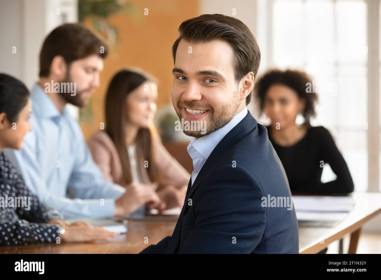 Giovane uomo d'affari allegro e di successo in posa per la telecamera Foto Stock
