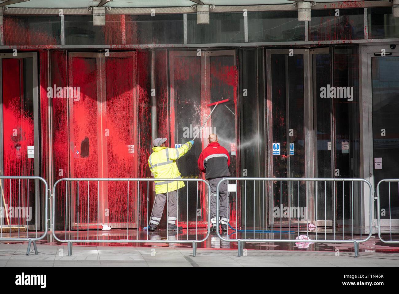 Londra, Regno Unito. 14 ottobre 2023. I lavoratori lavano via la vernice dall'ingresso della BBC Broadcasting House a Londra. Un gruppo pro-palestinese chiamato Palestine Action spruzzò vernice rossa all'ingresso della BBC Broadcasting House. Il gruppo di attivisti incolpa la BBC perché la sua copertura sul conflitto Israele-Hamas. La vernice rossa simboleggia la sua "complicità nel versare sangue palestinese”. Credito: SOPA Images Limited/Alamy Live News Foto Stock