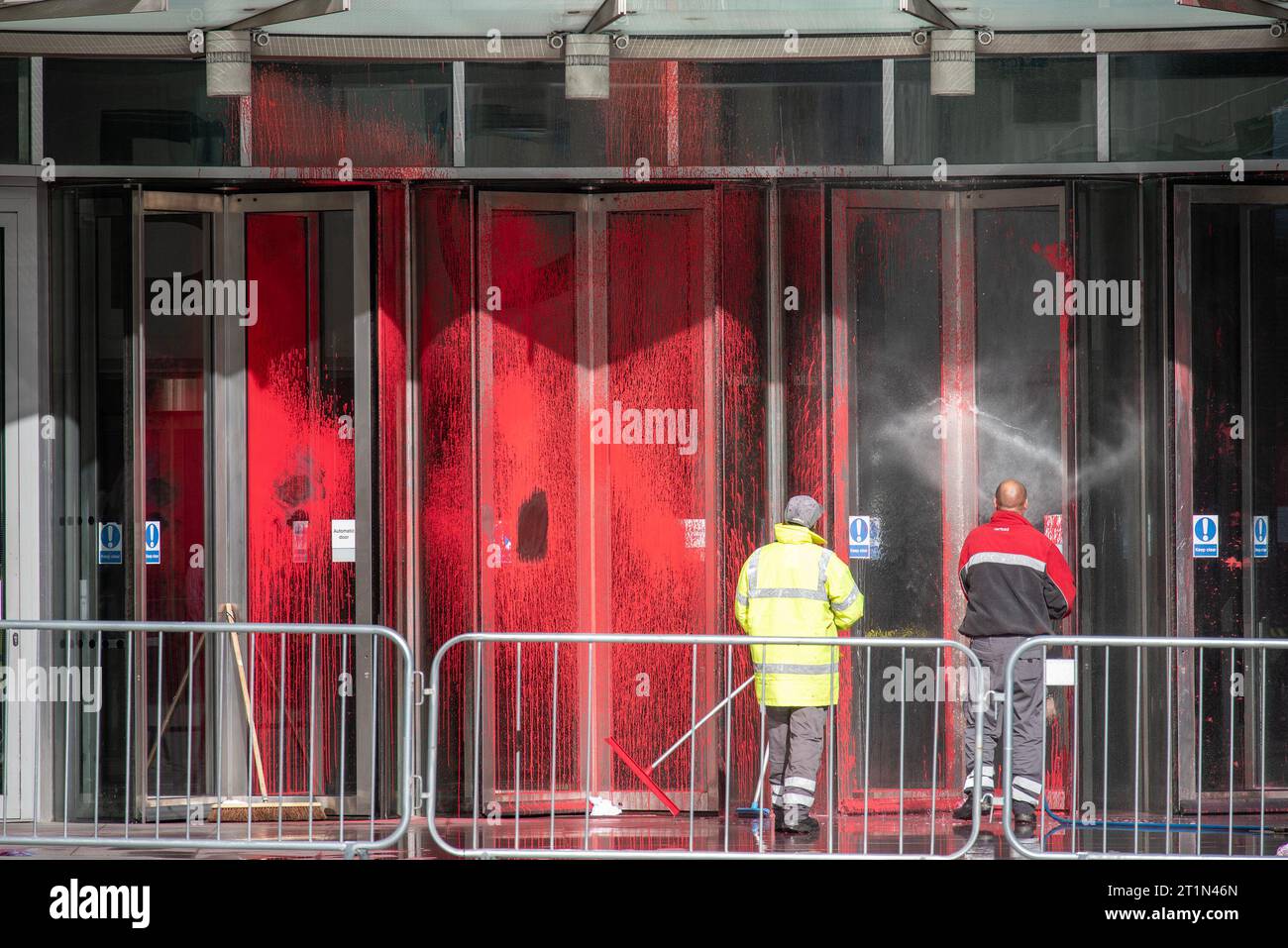 Londra, Regno Unito. 14 ottobre 2023. I lavoratori lavano via la vernice dall'ingresso della BBC Broadcasting House a Londra. Un gruppo pro-palestinese chiamato Palestine Action spruzzò vernice rossa all'ingresso della BBC Broadcasting House. Il gruppo di attivisti incolpa la BBC perché la sua copertura sul conflitto Israele-Hamas. La vernice rossa simboleggia la sua "complicità nel versare sangue palestinese”. Credito: SOPA Images Limited/Alamy Live News Foto Stock