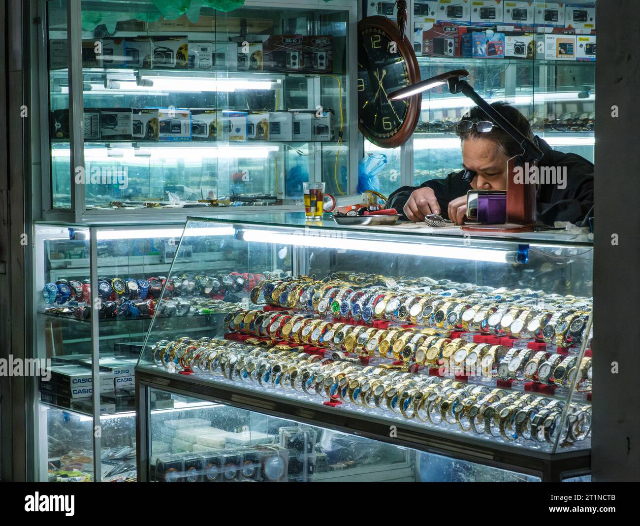 Cat Ba, Vietnam. Guarda il negoziante che ripara Watch. Foto Stock