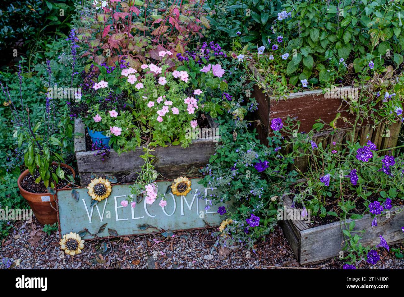 Un cartello di benvenuto in un giardino Foto Stock