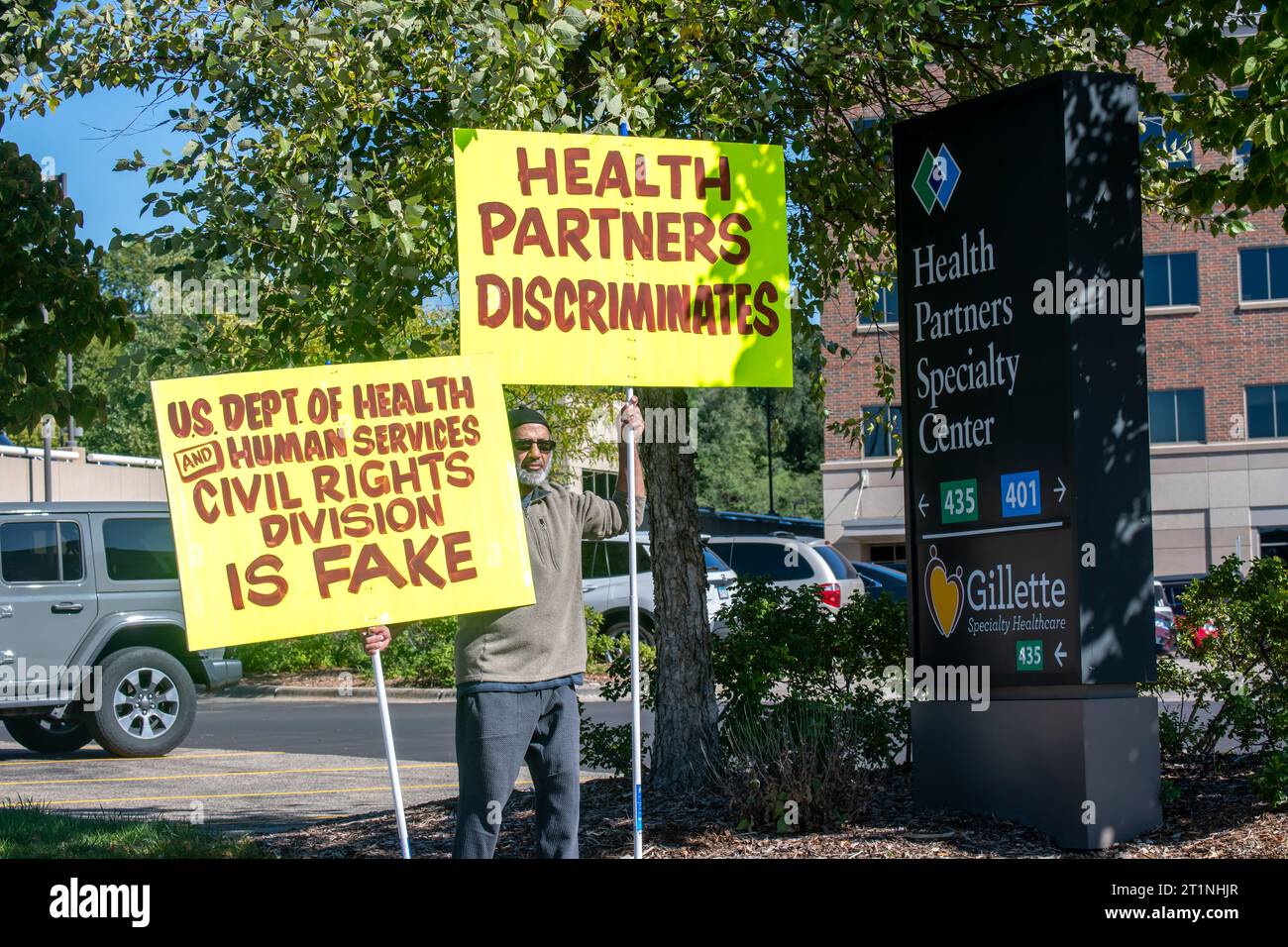 St Paul, Minnesota. Un uomo protesta contro Health Partners, un fornitore di assistenza sanitaria senza scopo di lucro e compagnia di assicurazione sanitaria. Il manifestante dice che W Foto Stock