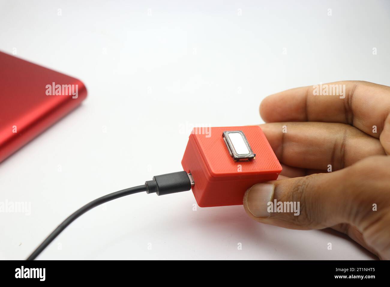 Piccolo altoparlante bluetooth realizzato con parti stampate in 3d e un mini altoparlante bassi può essere ricaricato utilizzando il cavo USB tenuto in mano Foto Stock