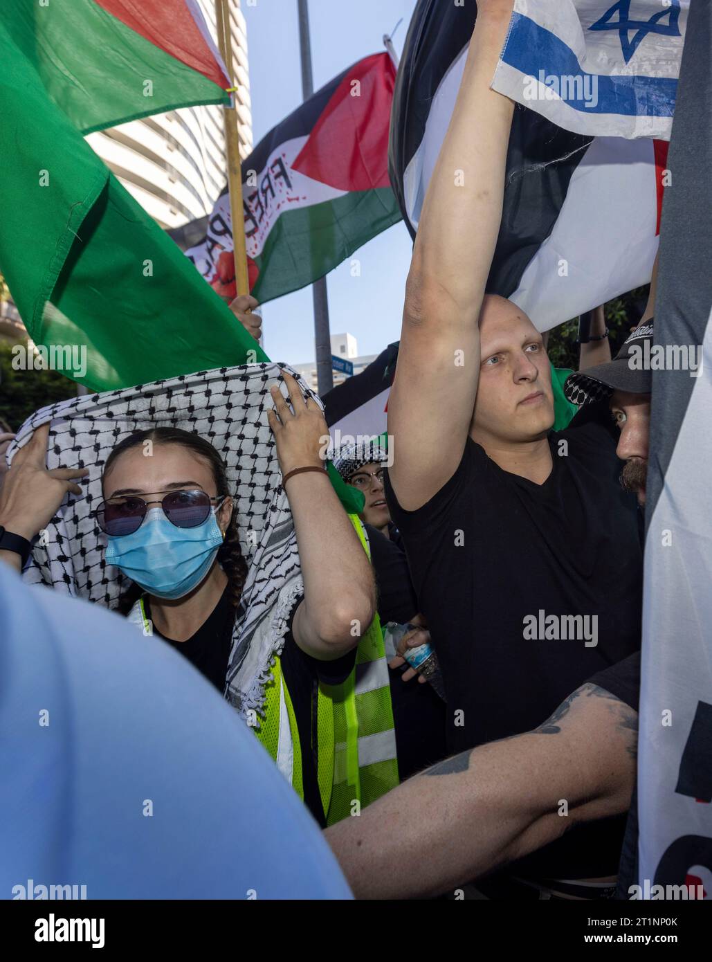 Los Angeles, California, USA. 14 ottobre 2023. Jeffrey Rosenberg, che è ebreo, (a destra) detiene una bandiera israeliana mentre i manifestanti marciavano lungo Wilshire Boulevard fino al Federal Building per protestare a sostegno dei palestinesi catturati nella guerra israelo-Hamas. (Immagine di credito: © Jill Connelly/ZUMA Press Wire) SOLO USO EDITORIALE! Non per USO commerciale! Foto Stock