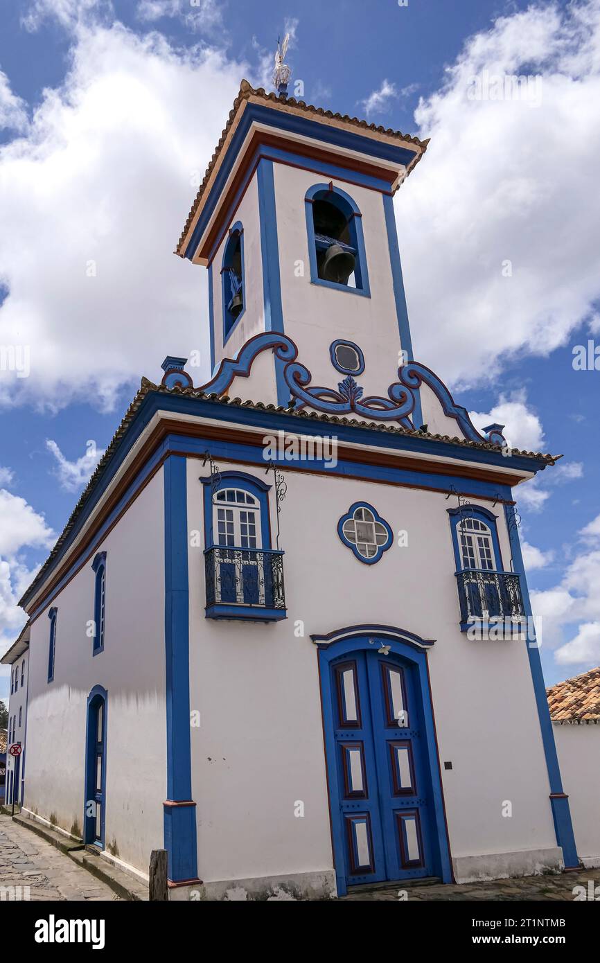 Ammira la piccola e bellissima cappella in bianco e blu contro il cielo blu con le nuvole bianche nella storica città di Diamantina, Minas Gerais, Brasile Foto Stock