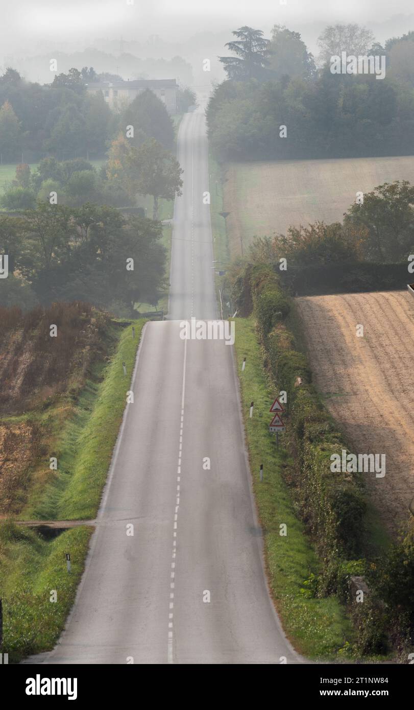 una lunga striscia di asfalto dritta tra le colline Foto Stock