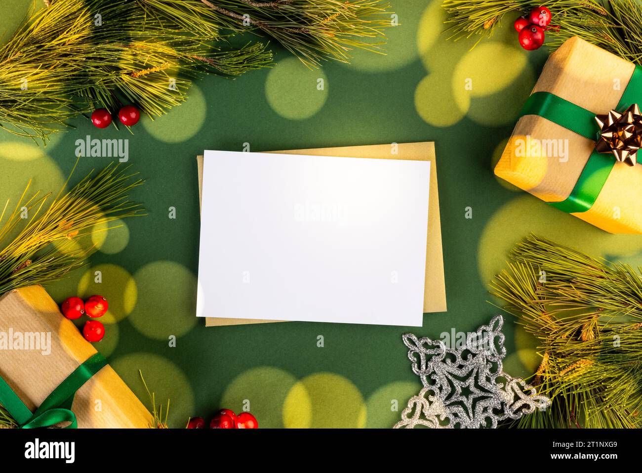 Decorazioni natalizie e cartolina bianca con spazio per le copie su sfondo verde Foto Stock