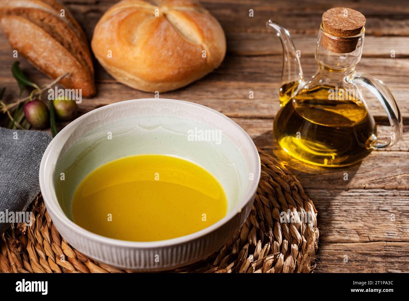 Recipiente con olio d'oliva accanto a una lattina d'olio e alcuni panini. Foto Stock