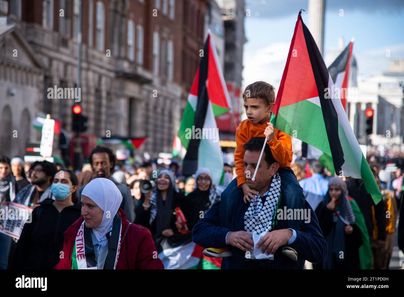 Londra, Regno Unito. 14 ottobre 2023. Un manifestante con un bambino seduto sulle spalle partecipa alla manifestazione nazionale - marcia per la Palestina. I manifestanti sono scesi in piazza per chiedere a Israele di porre fine alla sua violenta imposizione di un sistema di occupazione, apartheid e colonizzazione sul popolo palestinese. (Foto di Loredana Sangiuliano/SOPA Images/Sipa USA) credito: SIPA USA/Alamy Live News Foto Stock