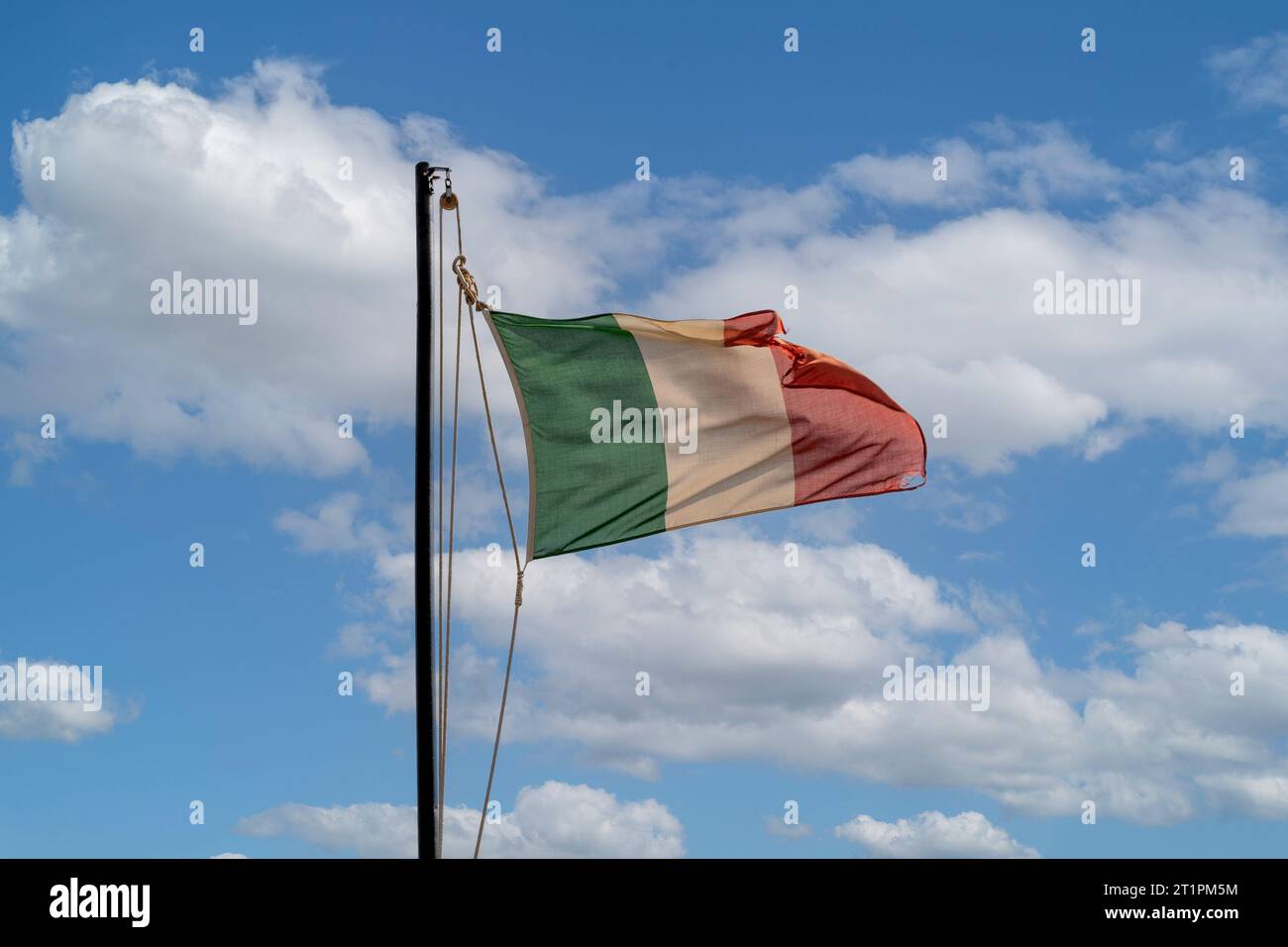 Una bandiera italiana che sventola contro il cielo blu Foto Stock