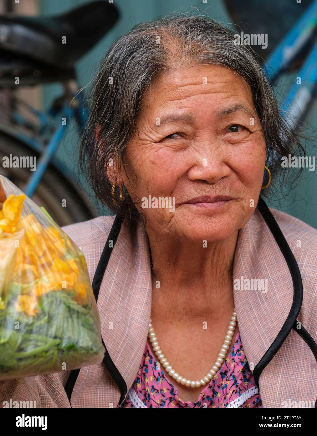 Long Khe, provincia di Bac Ninh, Vietnam. Donna di mezza età con i suoi acquisti al mercato. Foto Stock