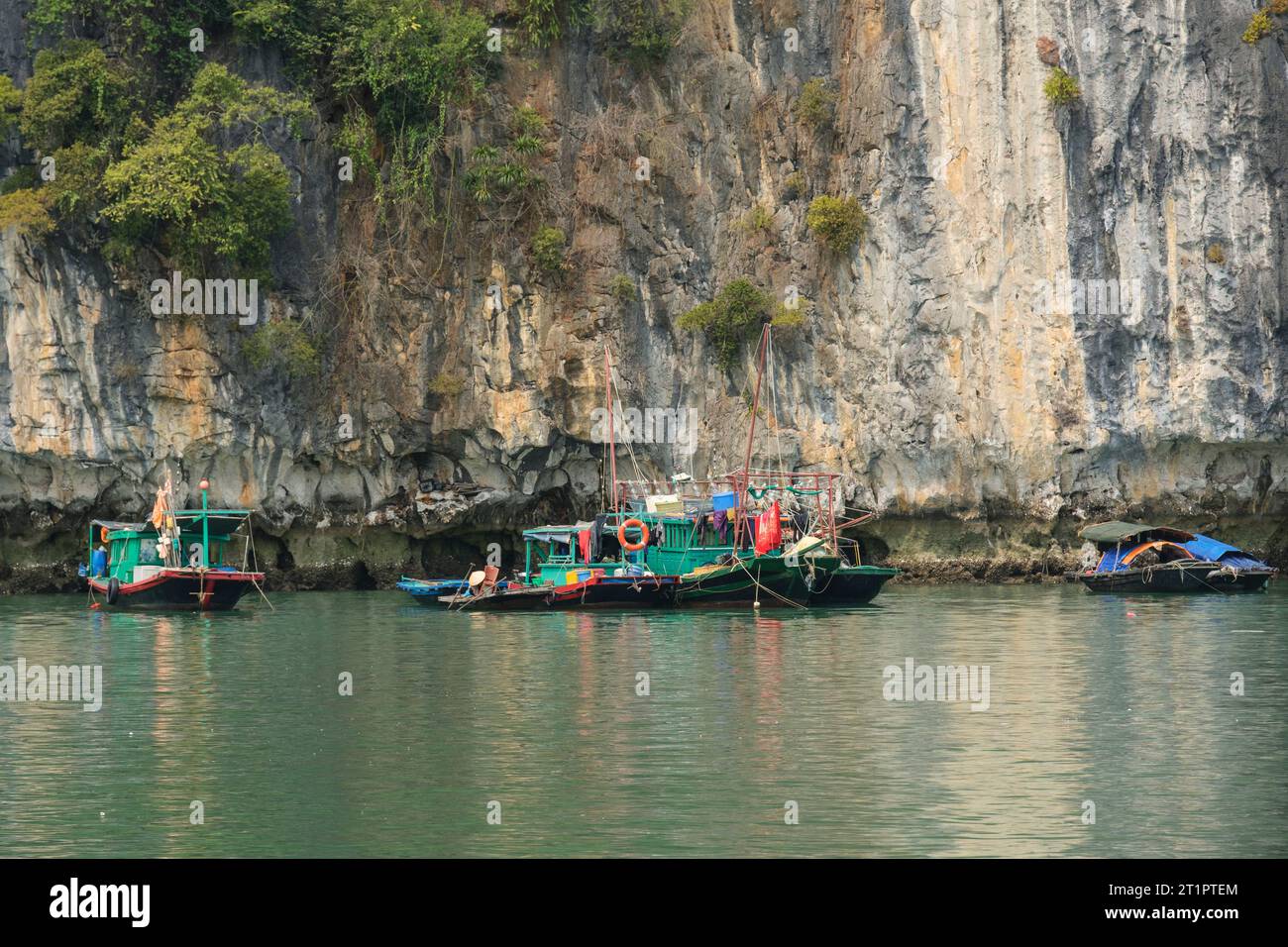 Ha Long Bay, Vietnam. Barche da pesca a bordo di carsiche calcaree nella baia. Foto Stock