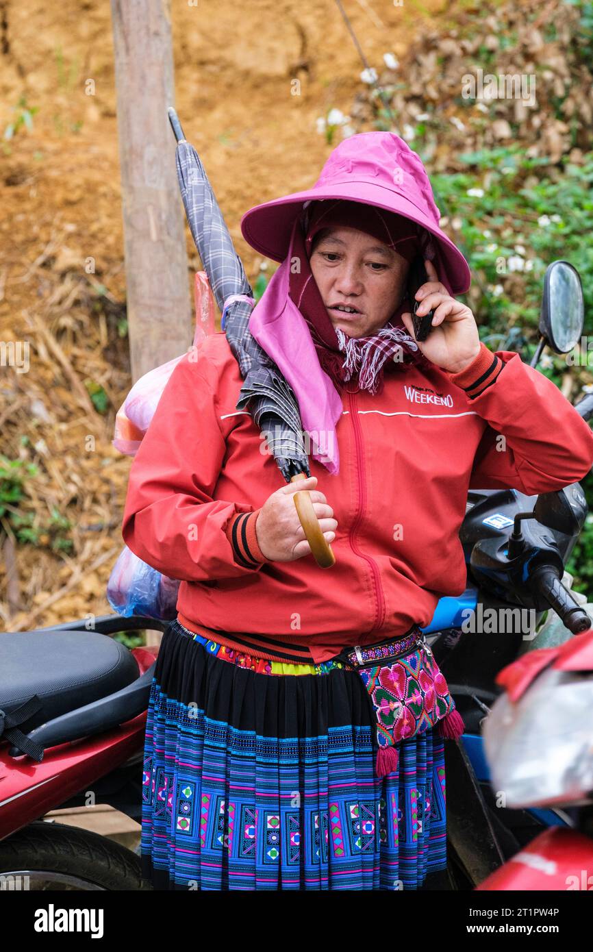 CAN Cau Market Scene, Vietnam. Hmong Woman che ascolta il suo cellulare. Provincia di Lao Cai. Foto Stock