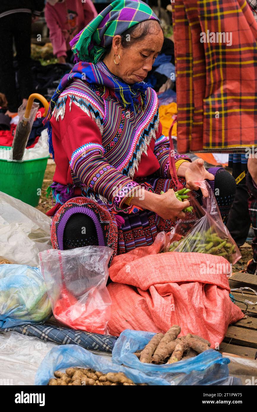 CAN Cau Market Scene, Vietnam. Hmong donna che mette i fagioli in una borsa. Provincia di Lao Cai. Foto Stock