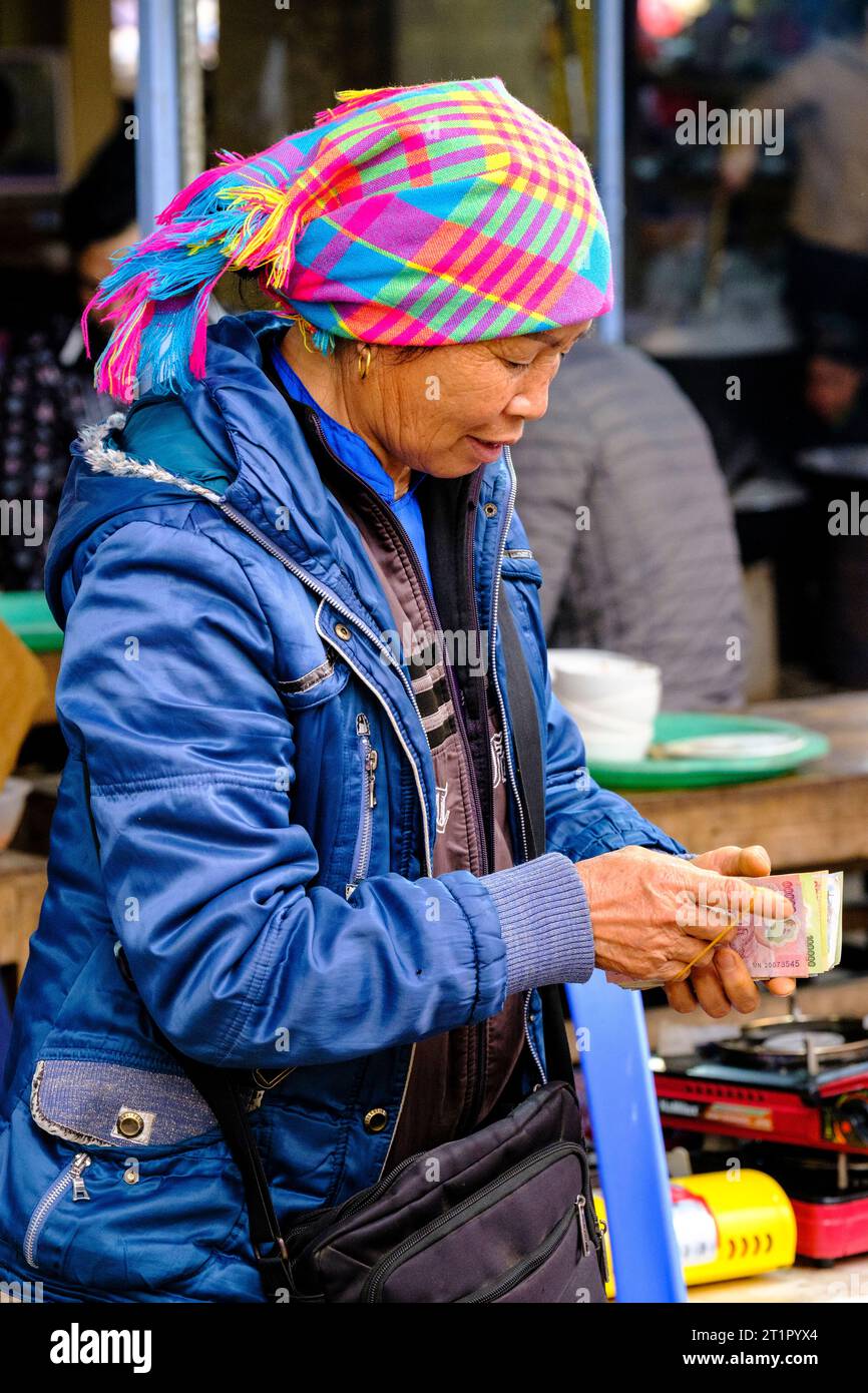 BAC ha, Vietnam. Sunday Market Scene, Hmong donna che conta soldi. Provincia di Lao Cai. Foto Stock